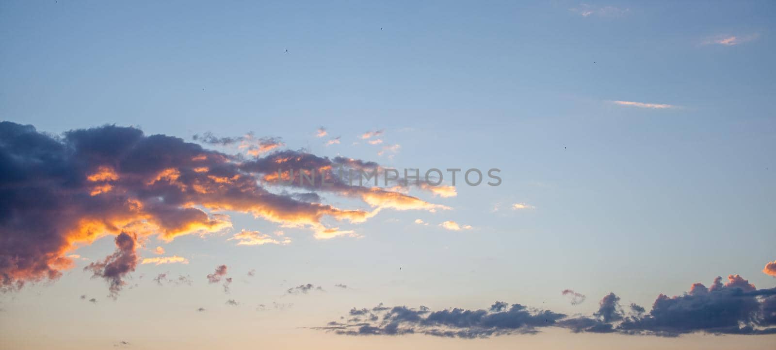 Colorful sunset or sunrise in the sky. The clouds are brightly colored. Beautiful background.