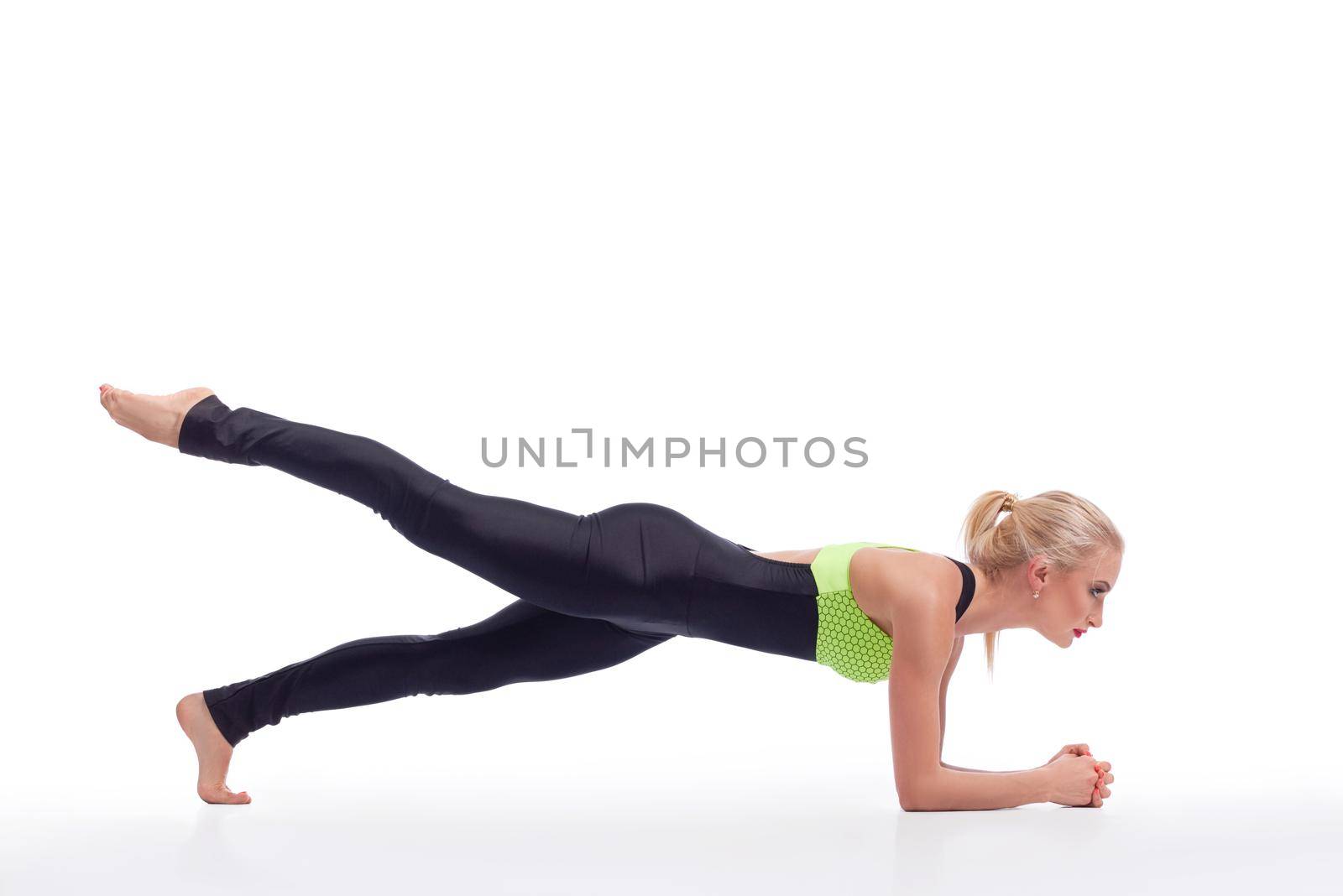 Strengthening her core. Sporty woman doing planking exercise at studio isolated copyspace above