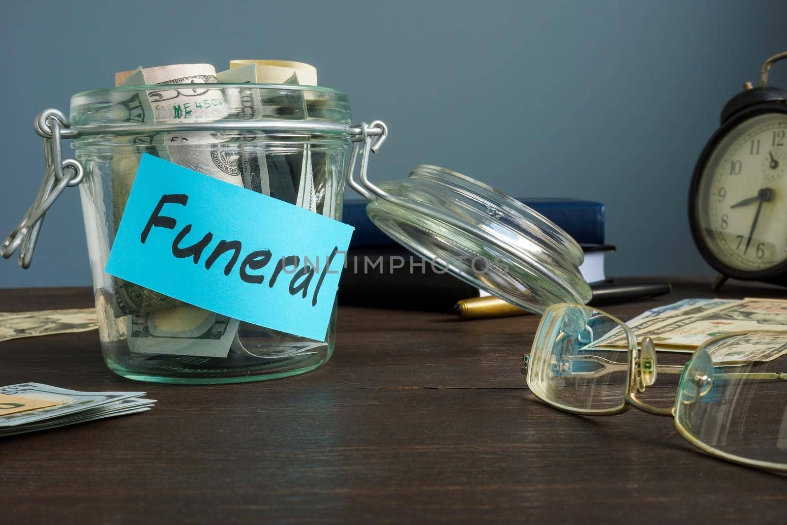 Funeral fund in the glass jar with money. by designer491