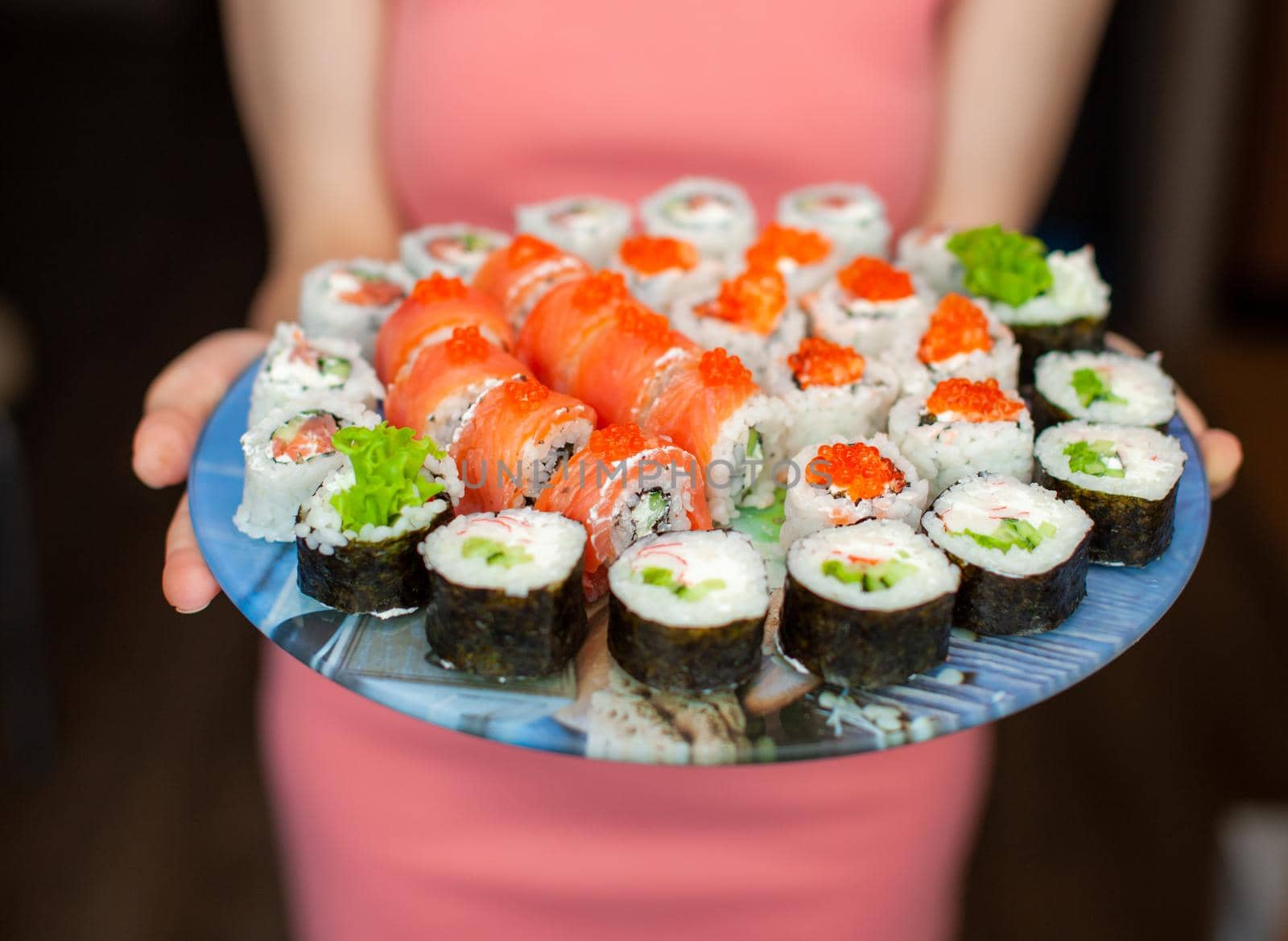 Making sushi and rolls at home. Sushi with seafood, salad and white rice. Food for family and friends. A set of different rolls and sushi on a tray.