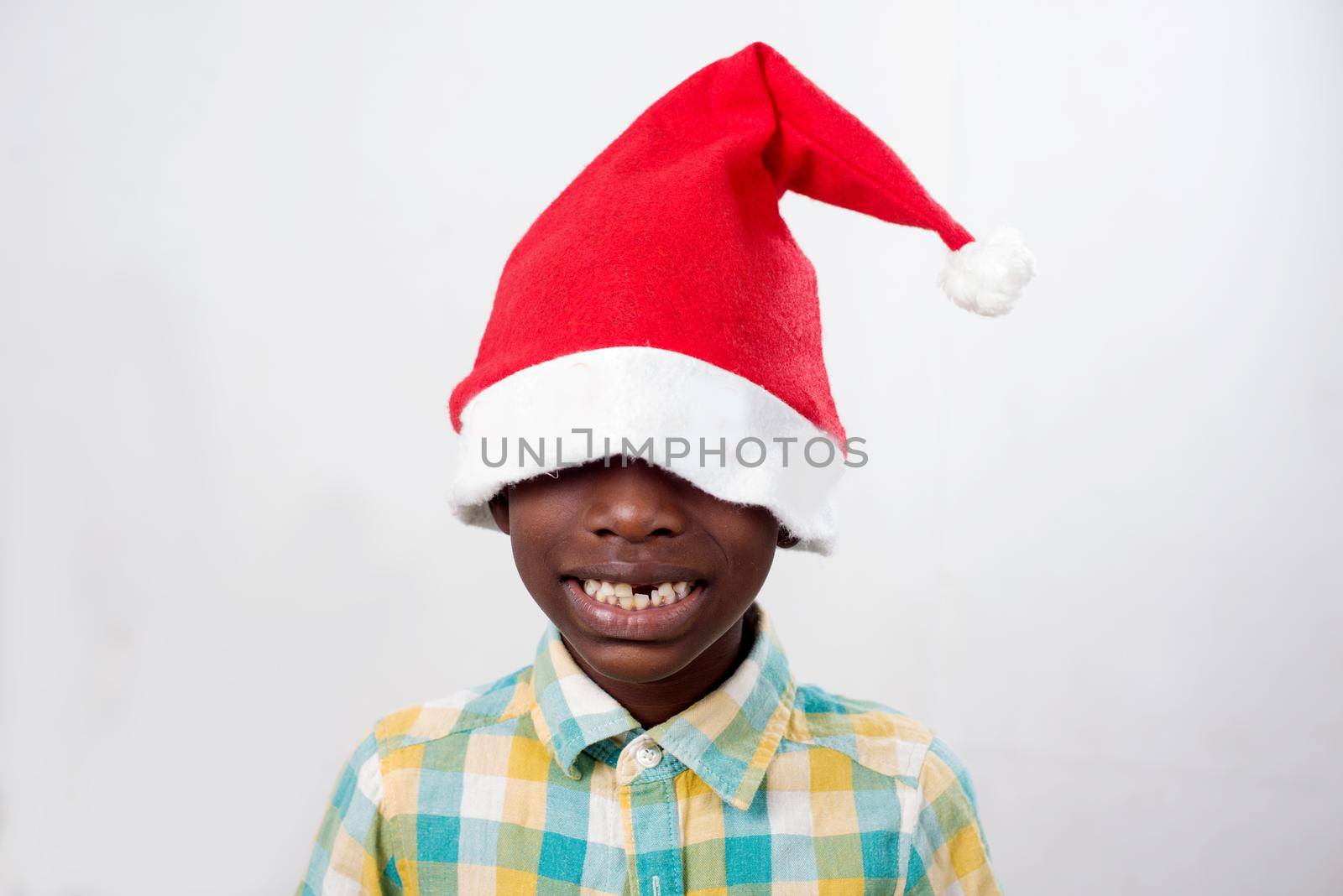 portrait of little happy boy wearing a Santa Claus hat isolated on white background.