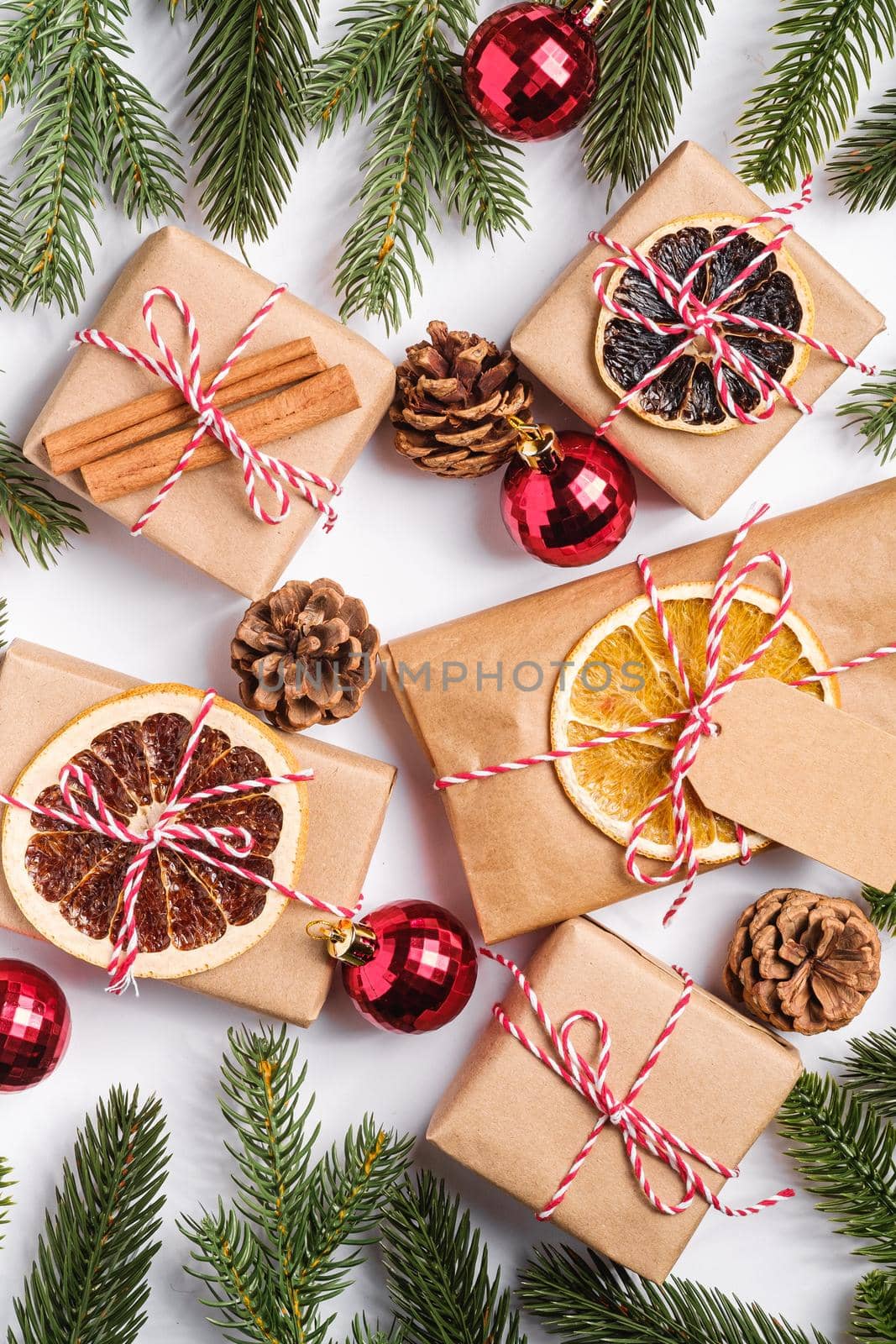 Christmas holidays zero waste paper gifts wrapping with tag, baubles, dried fruit and fir branches
