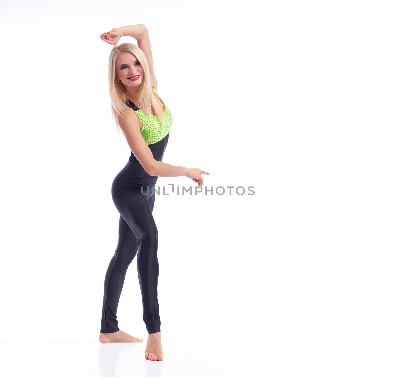 Grace of movement. Full length portrait of a beautiful fitness woman posing gracefully wearing sports outfit smiling joyfully isolated copyspace welcoming gym lifestyle sports body concept