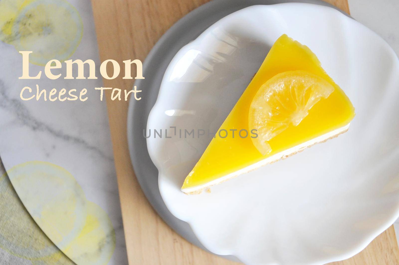 Top view of lemon cheese tart on white dish with wording and space for text on bright and clean background
