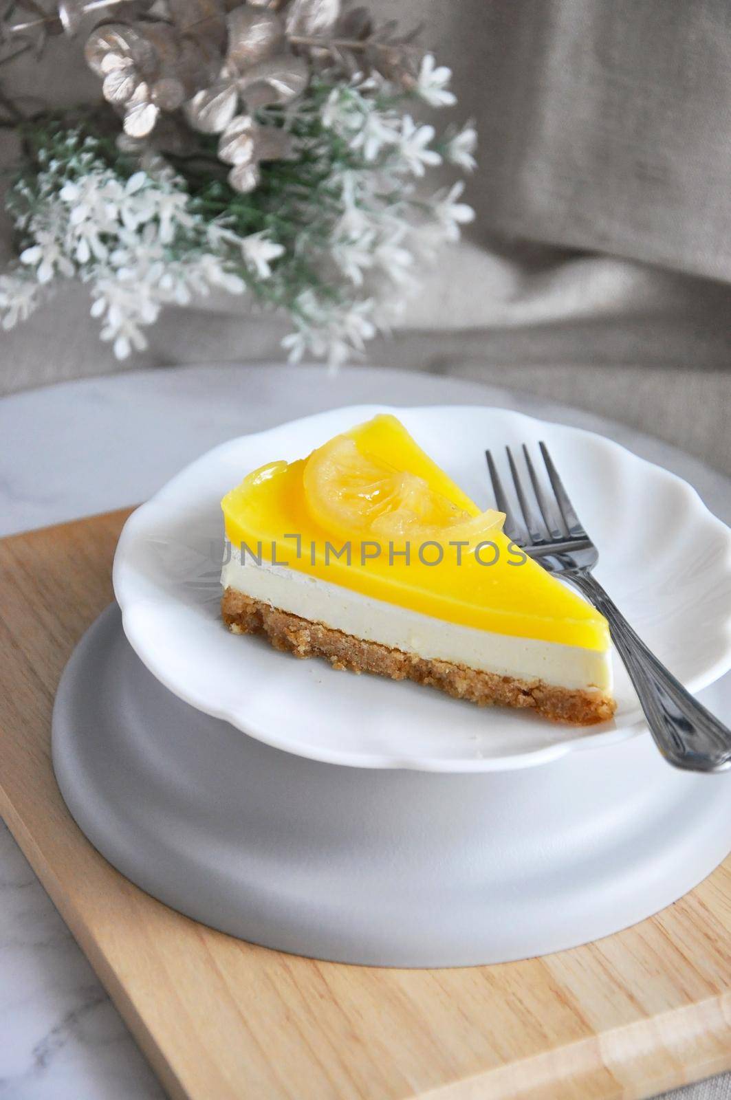Serving a piece of lemon cheese tart on white plate with copy space on neutral color background