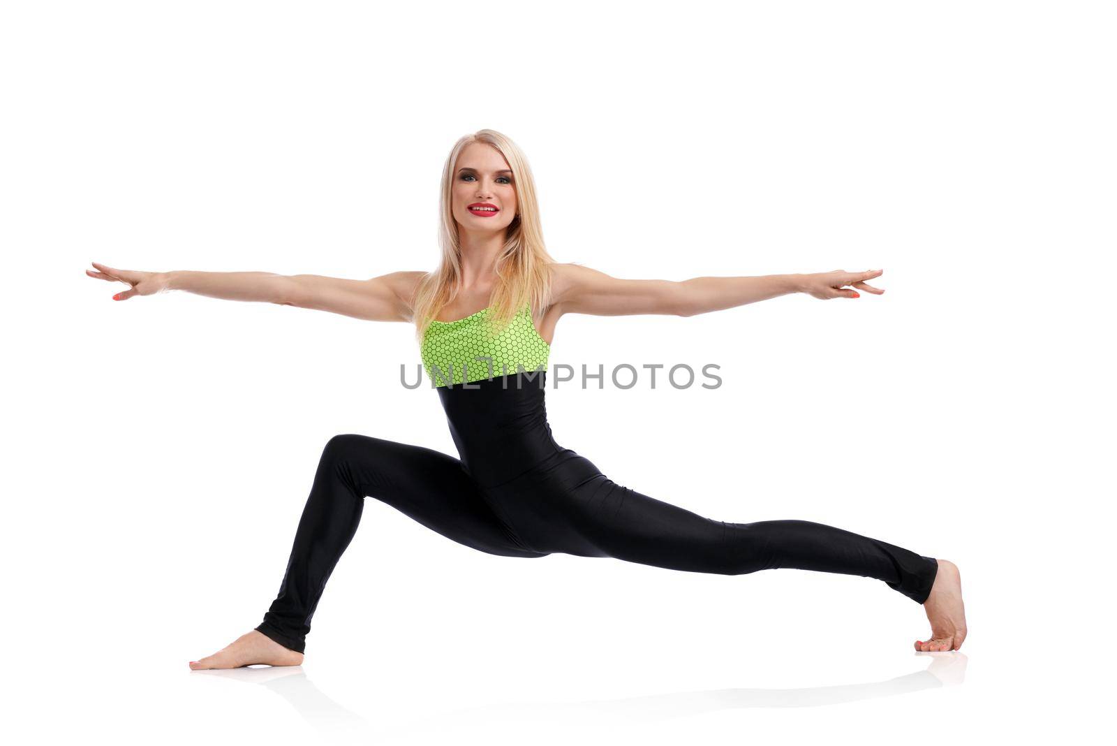 Focusing on posture. Beautiful happy and healthy woman smiling while doing yoga in studio isolated yoga fitness health life vitality concept