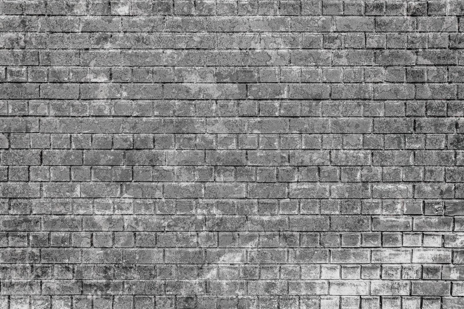 Old gray brick wall damaged and scuffed and peeled off as texture or background