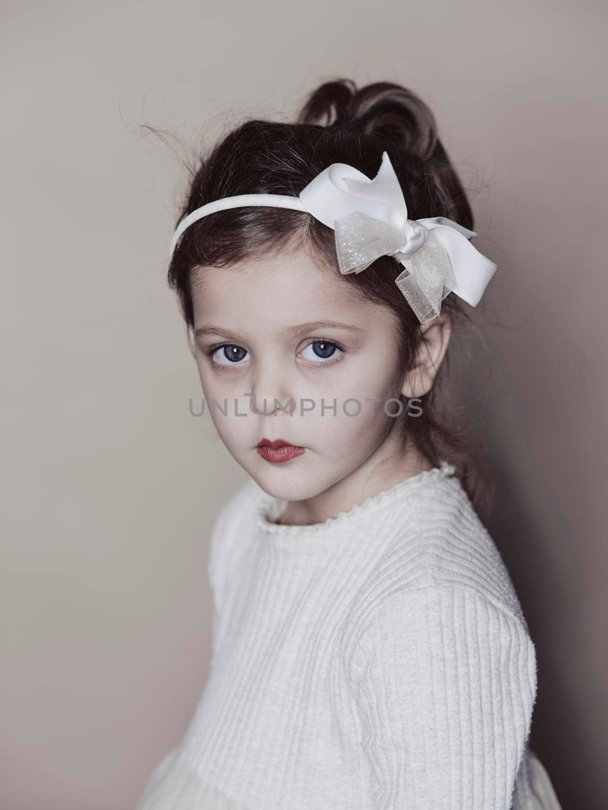 Portrait of little girl isolated on grey studio background by drmglc