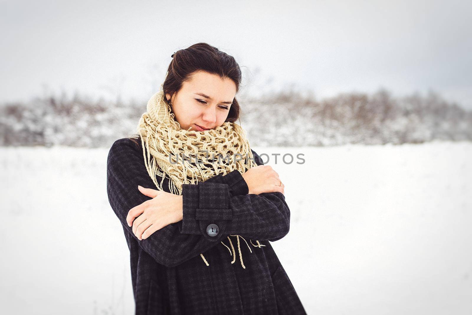 girl in warm clothes and scarves on a walk in the snowy forest and in the field