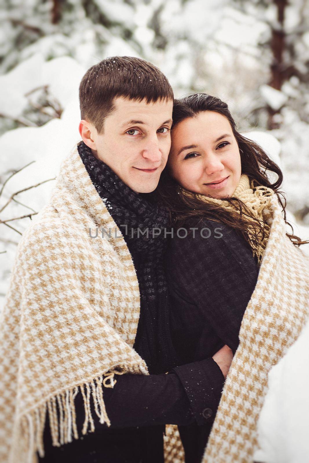 A guy and a girl in warm clothes and scarves on a walk in the snowy weather by Andreua