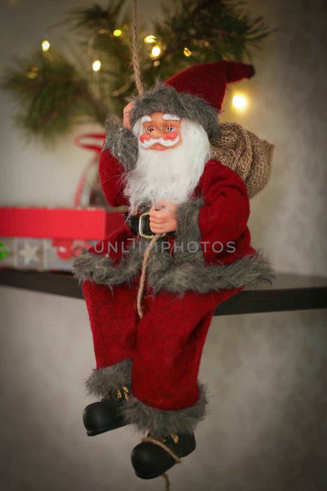 Toy Santa Claus sitting with gifts and Christmas decorations. Happy New Year coming