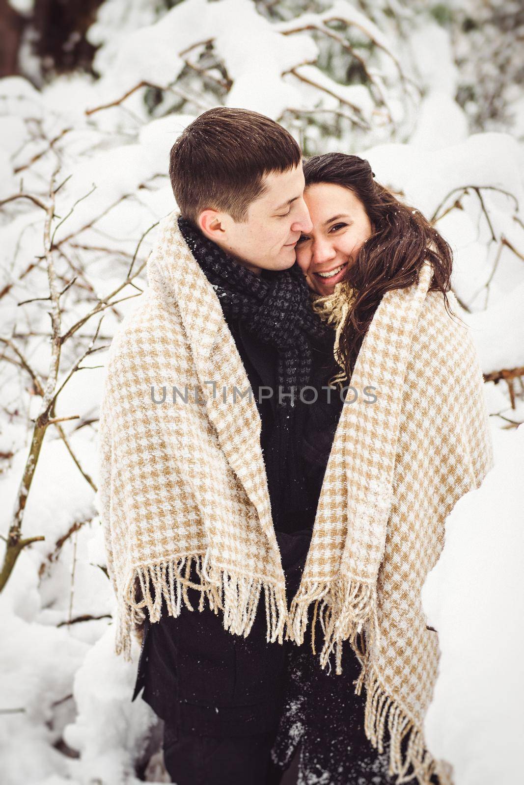 A guy and a girl in warm clothes and scarves on a walk in the snowy weather by Andreua