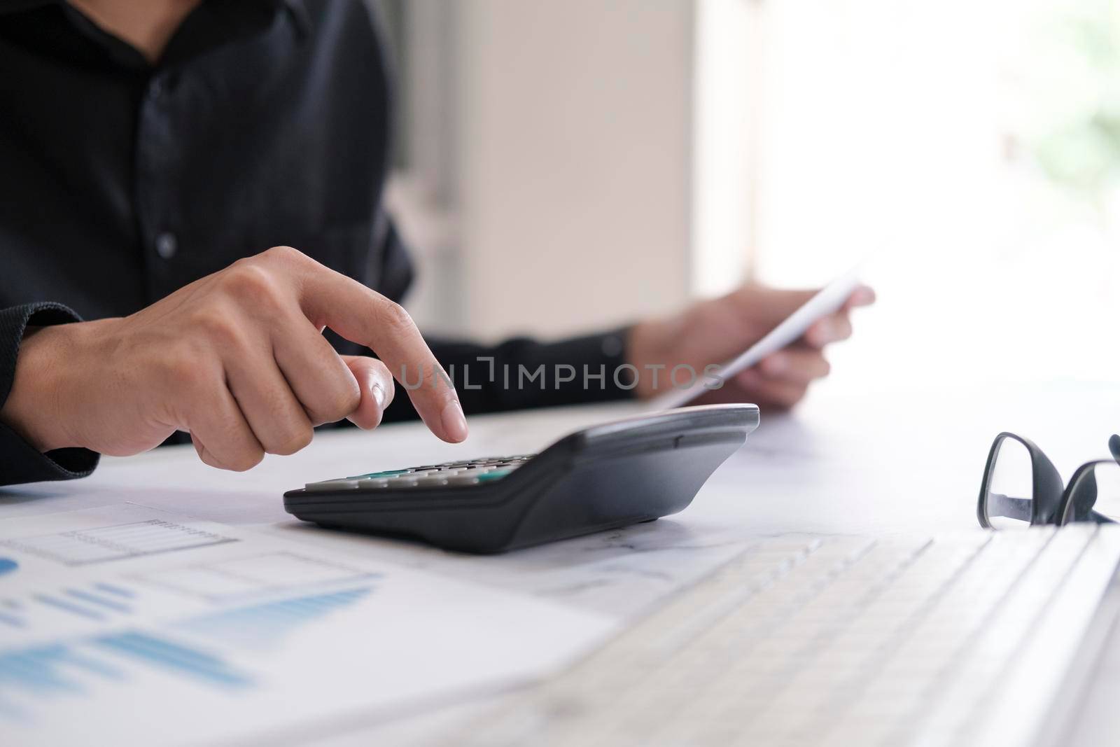 Business accounting concept, Business man using calculator with computer laptop, budget and loan paper in office.