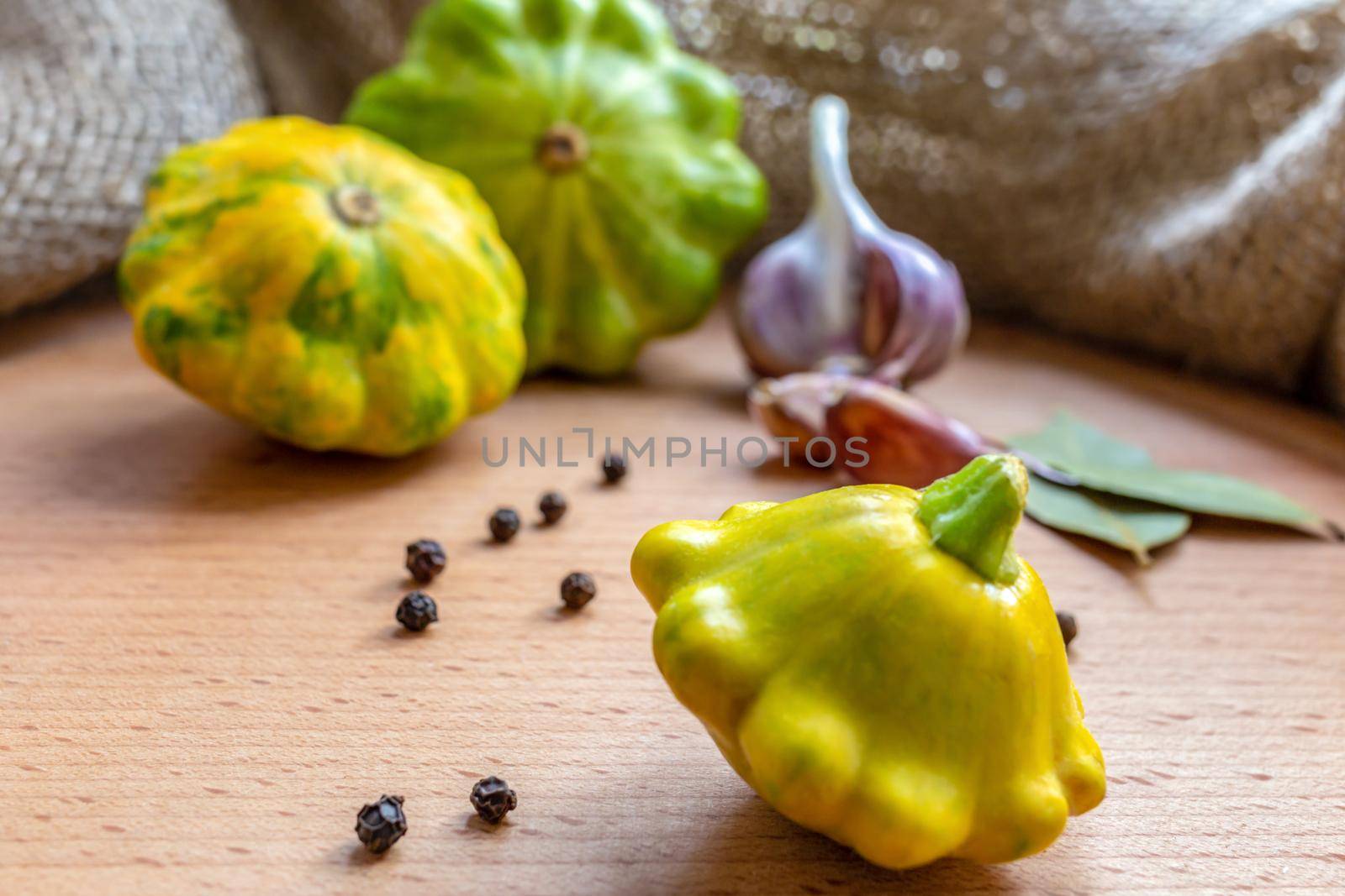 Garlic, peppercorns and squash on a wooden kitchen board by clusterx
