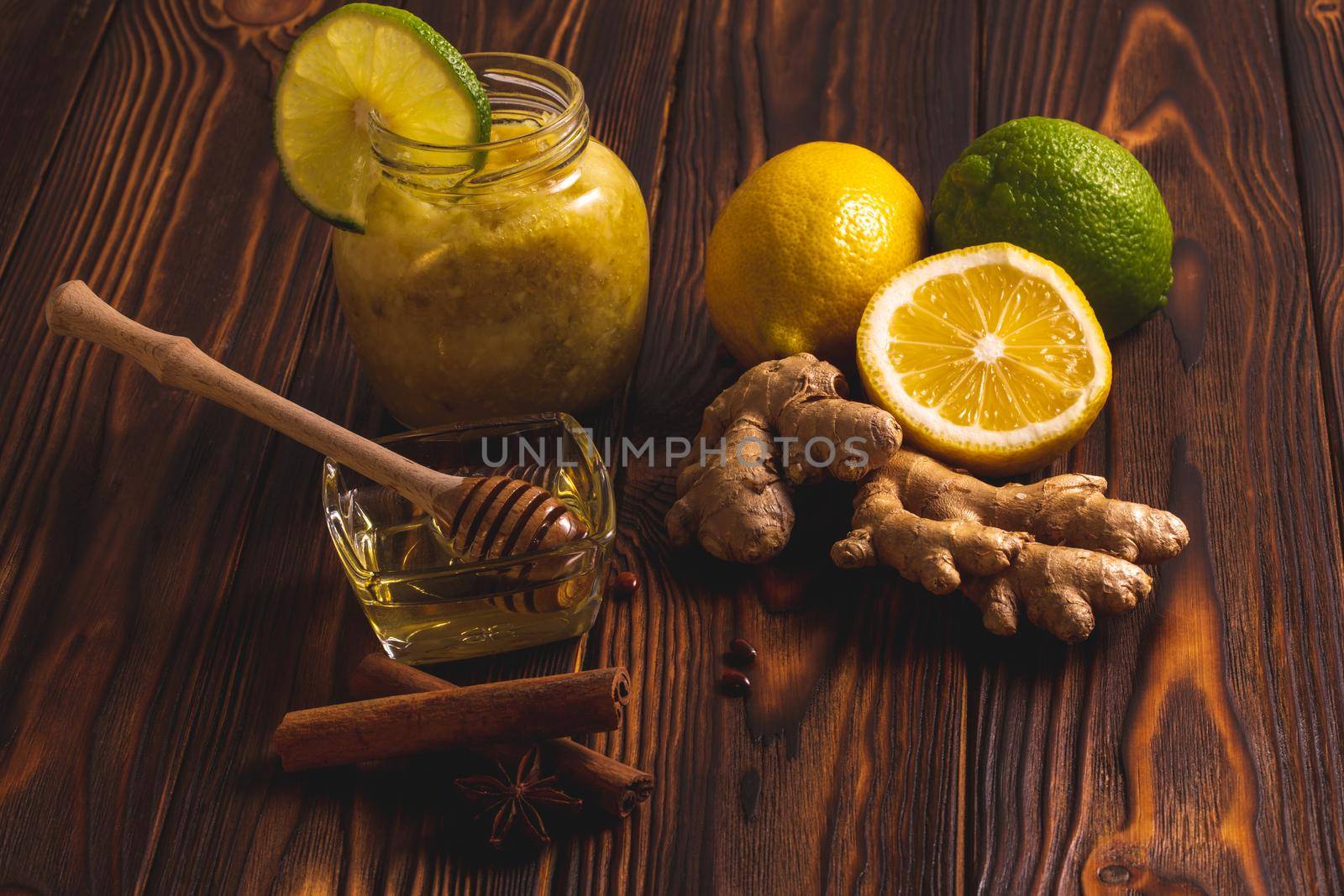 Ginger, lemon, honey, cinnamon on a dark wooden background. Cold cure recipe and healthy food