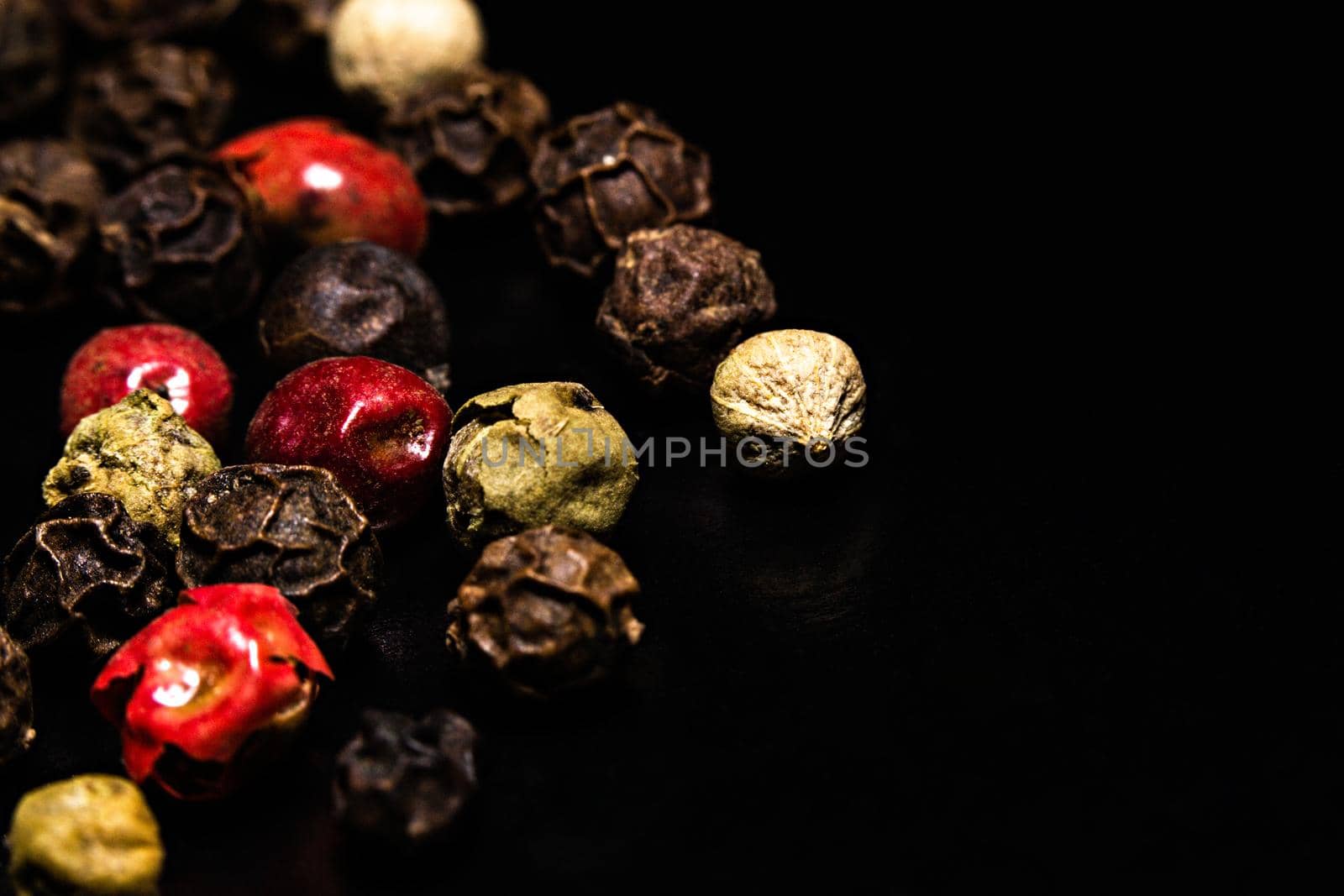 Colored dried pepper mix on a dark background by clusterx