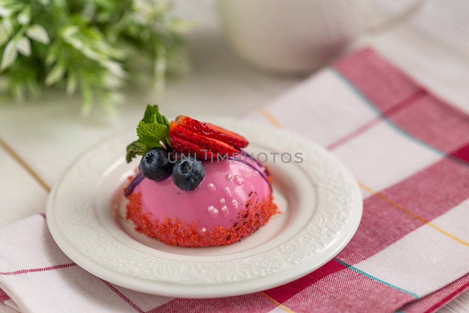 Blueberry mousse dessert on a white dessert plate by clusterx