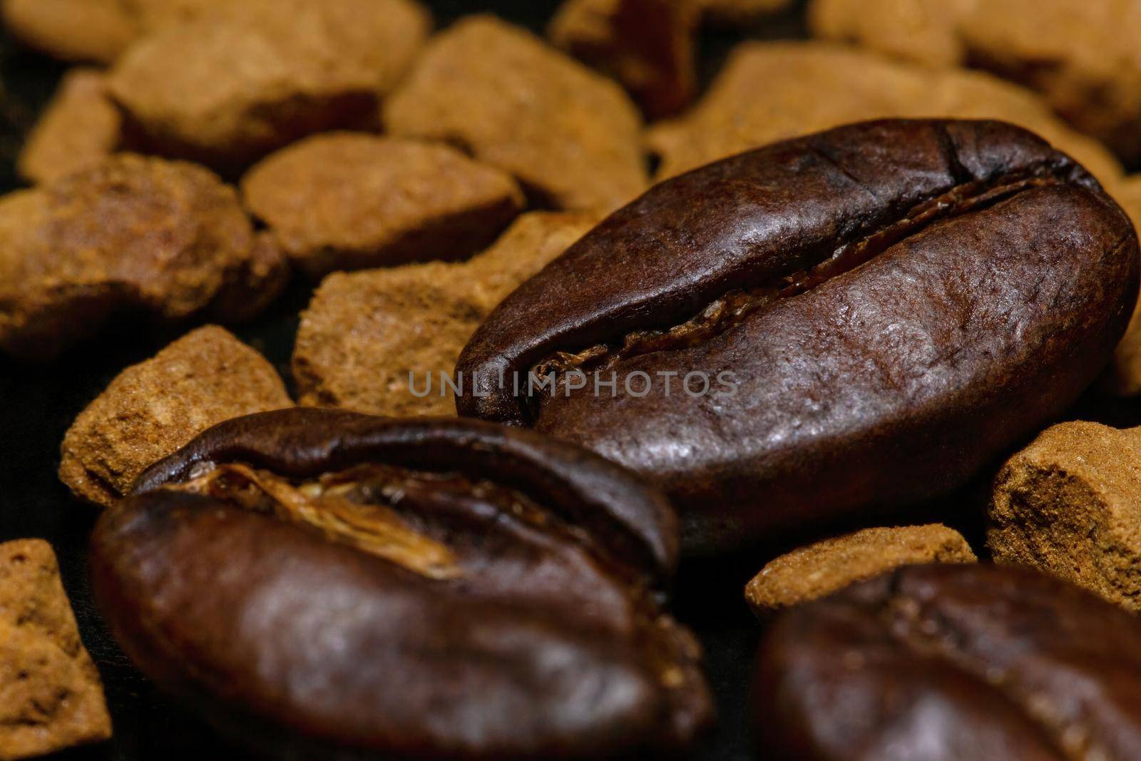 Coffee beans and instant coffee granules on a dark background, macro, close-up