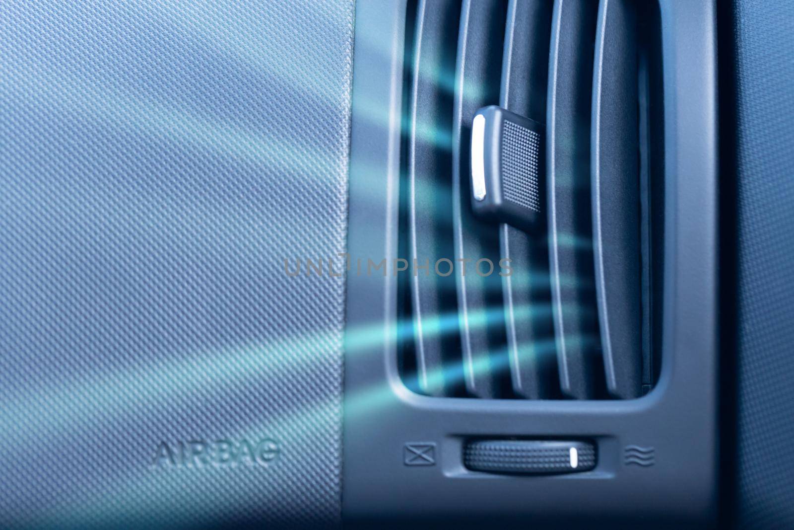 Car air conditioner with passenger airbag and illustration of cold air flow from it. Front view close up