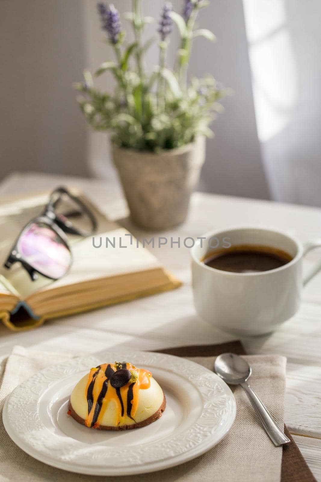 Still life with coffee, cake and a bouquet of lavender on white wooden table. Breakfast in the morning sun