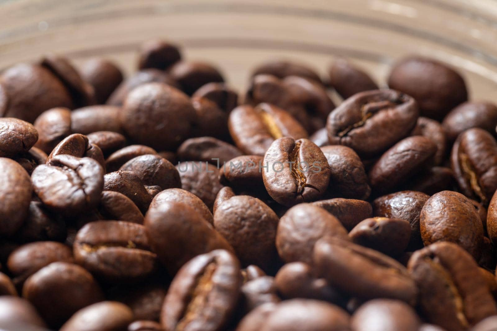 Roasted coffee beans in a glass jar. Macro view texture