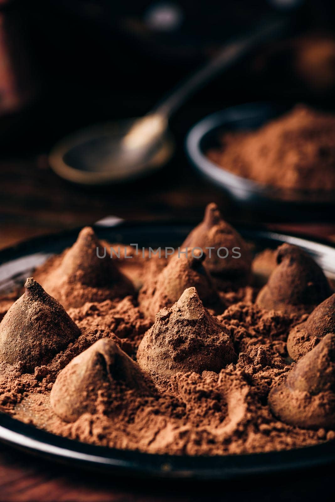 Homemade chocolate truffles coated in cocoa powder on metal tray