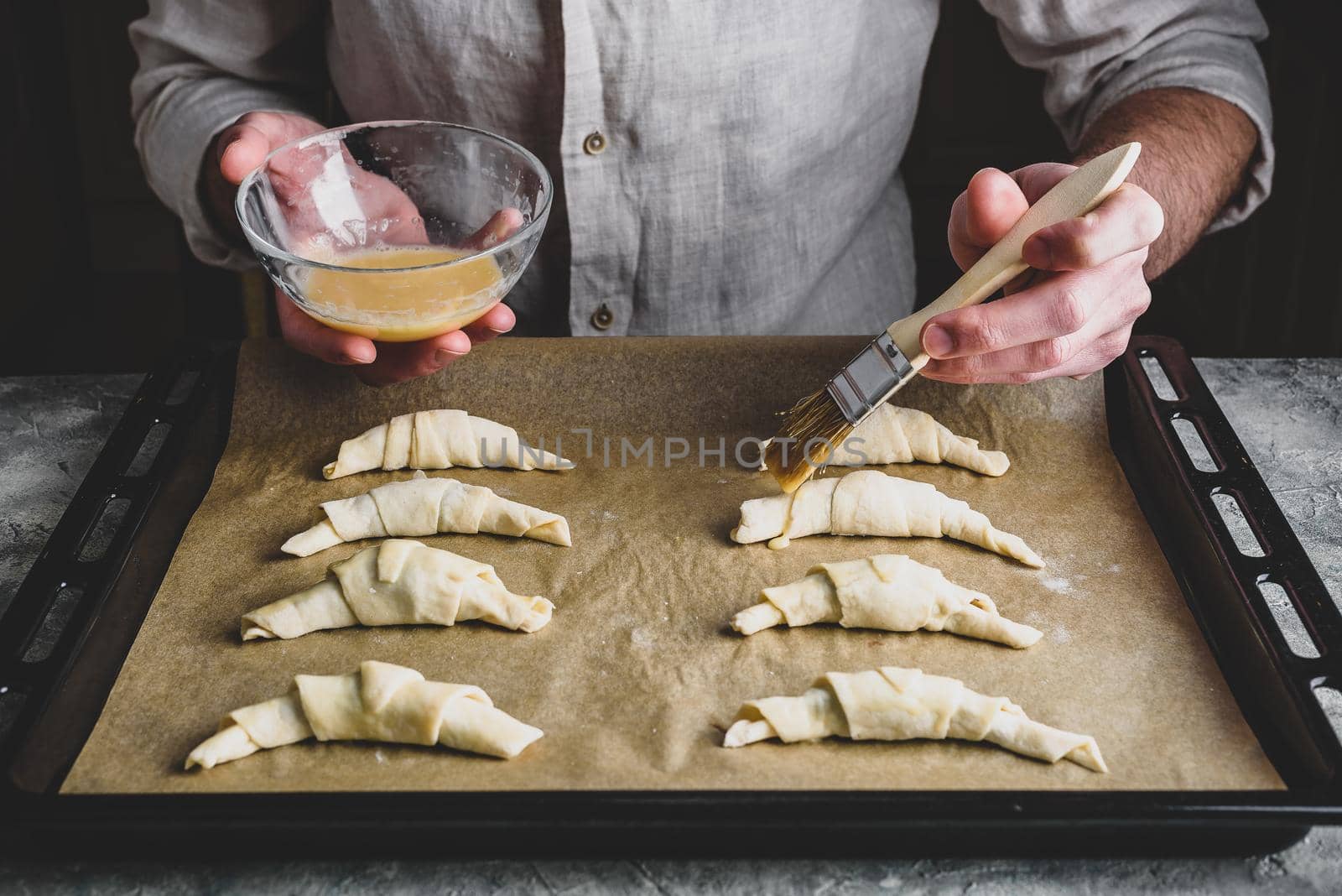 Baking sheet of raw homemade croissants stuffed with chocolate spread