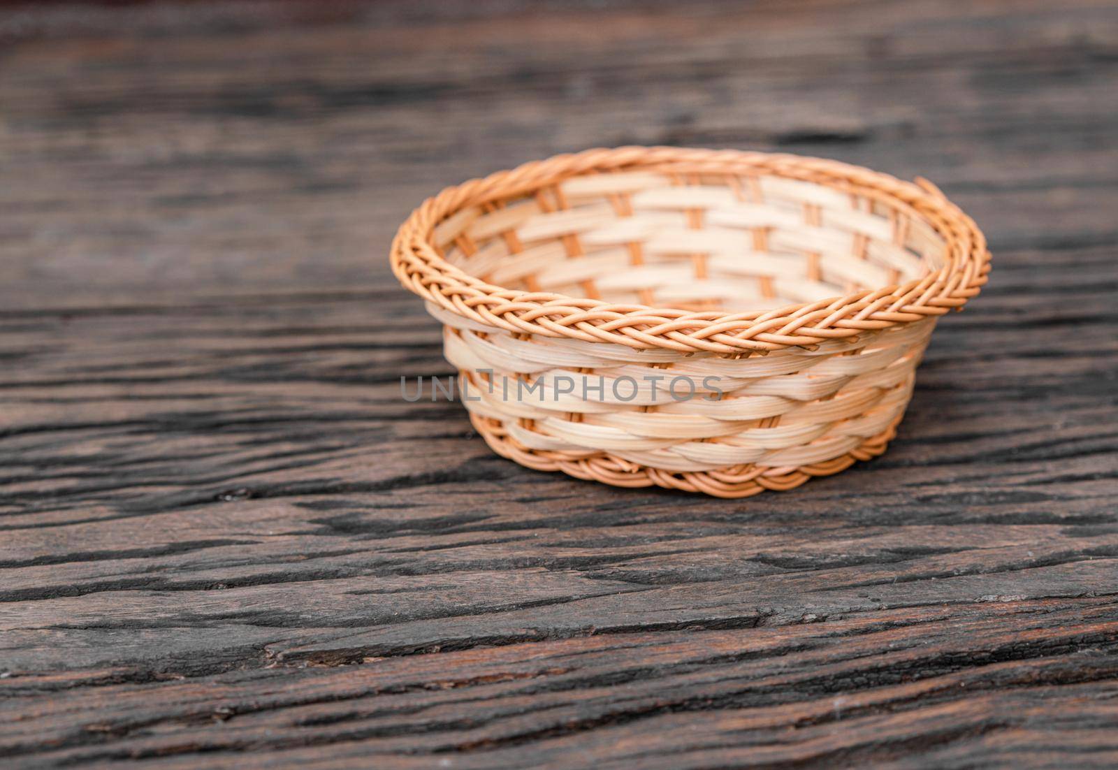 Wicker basket with copy space on wooden table by Buttus_casso