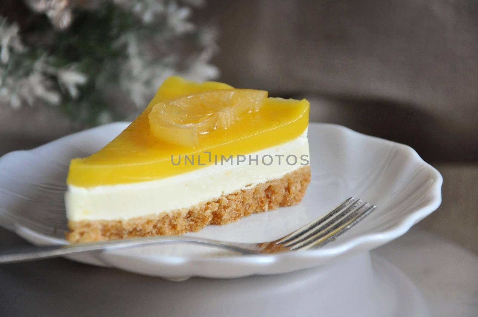 Close up a piece of lemon cheese tart on white dish with copy space
