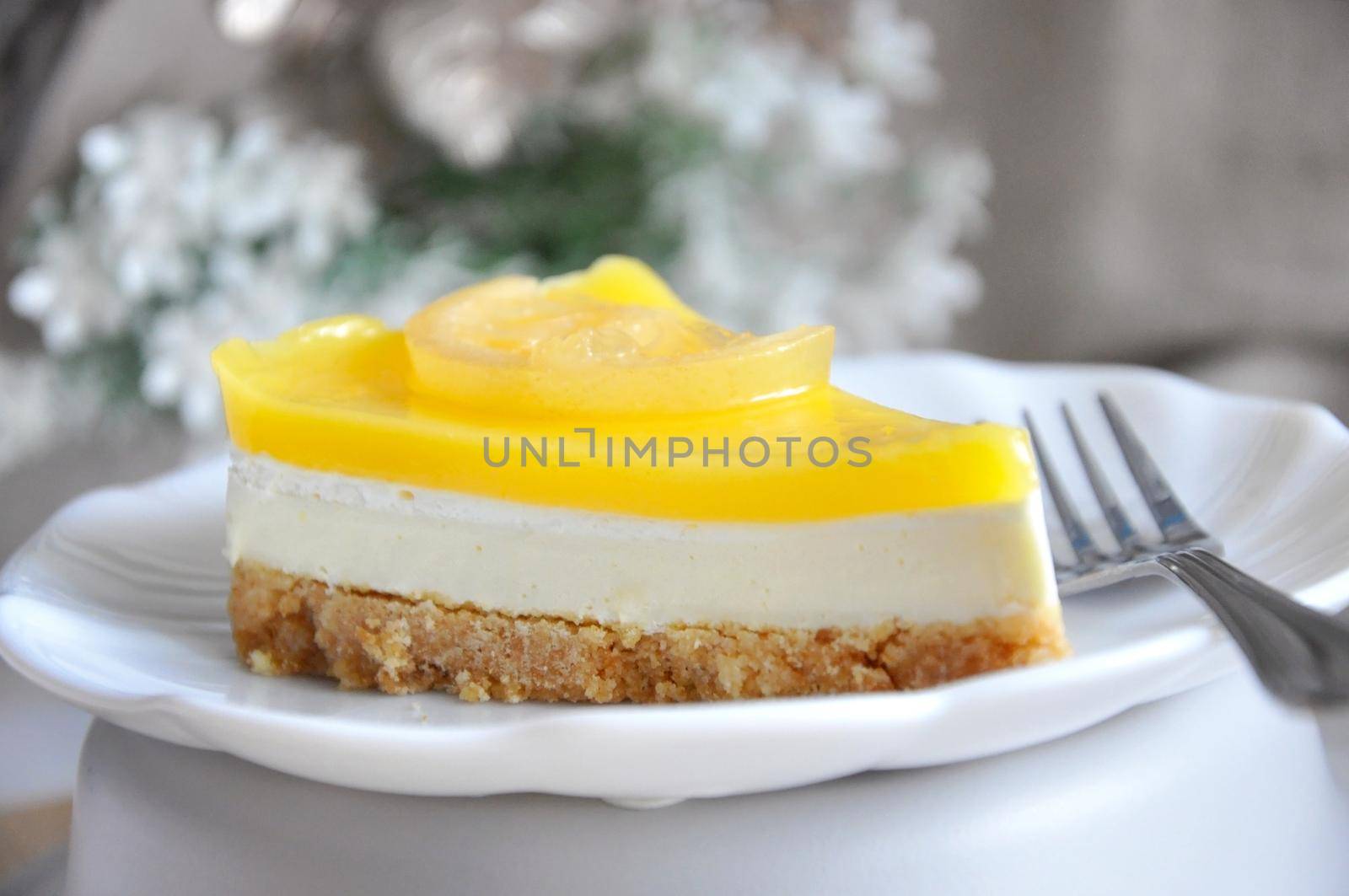Close up layer of fresh and delicious lemon cheese tart on white plate