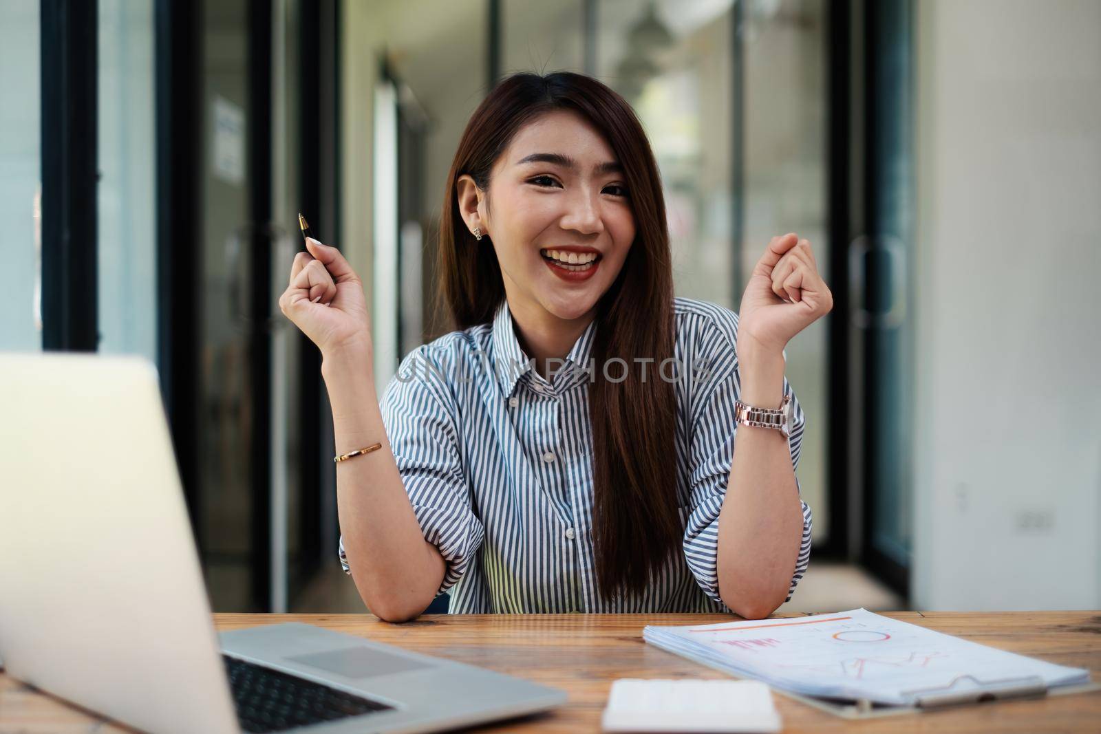 Joyful businesswoman sitting at desk looking at laptop screen talking with friend make informal video call.