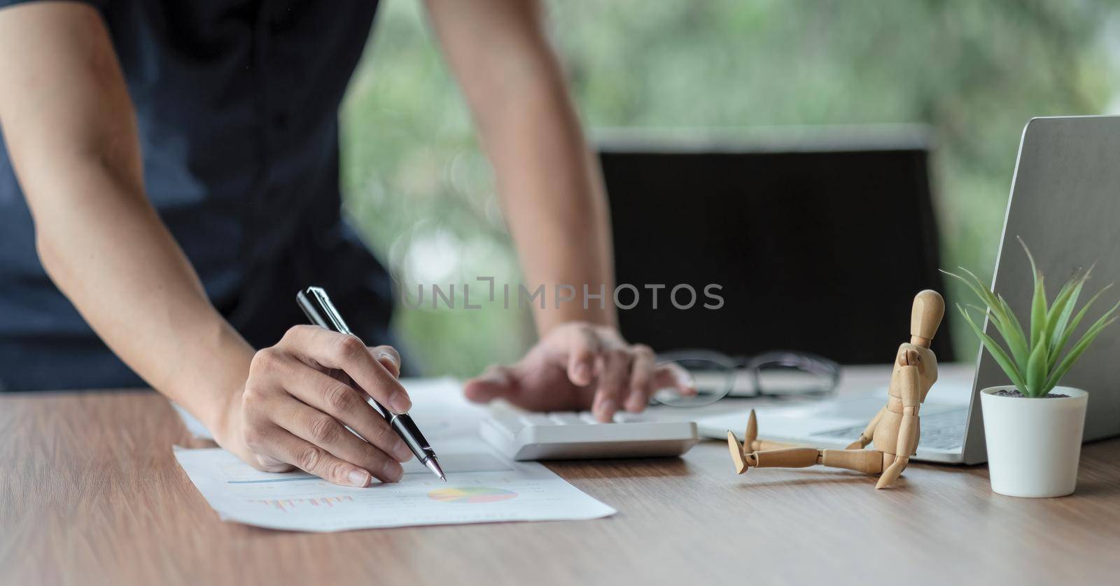 businessman accountant working on desk office with using a calculator to calculate the numbers, finance accounting concept