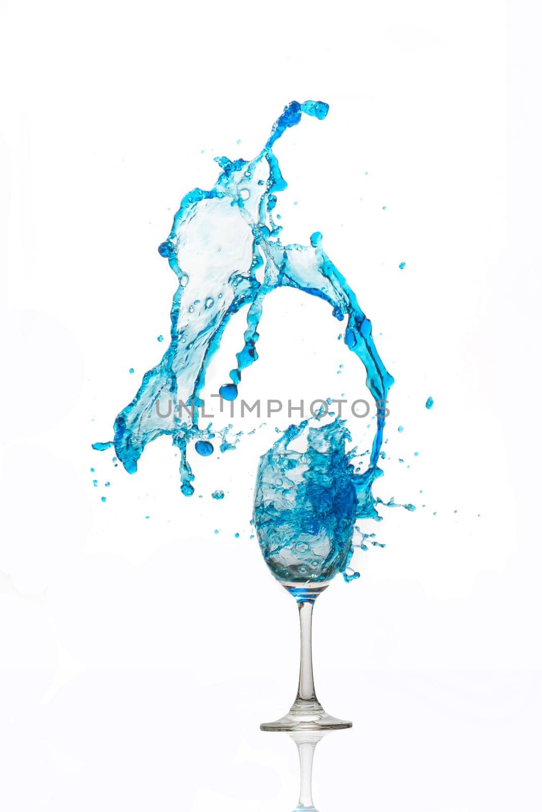 Wine glass on white background whit a blue water splash. by thanumporn