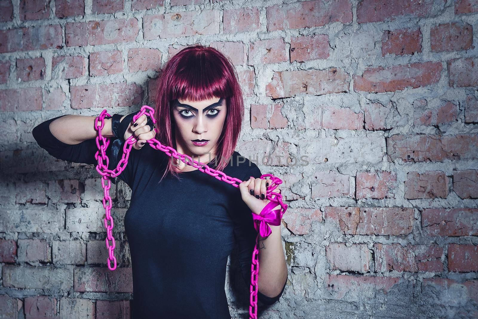 girl model in black with pink hair in an abandoned building