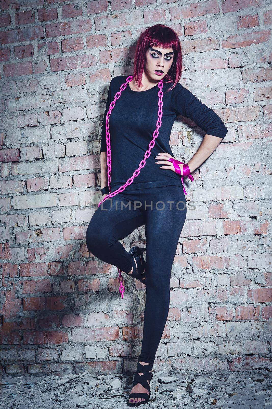 girl model in black with pink hair in an abandoned building