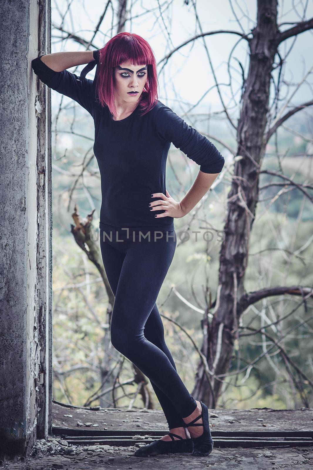 girl model in black with pink hair in an abandoned building