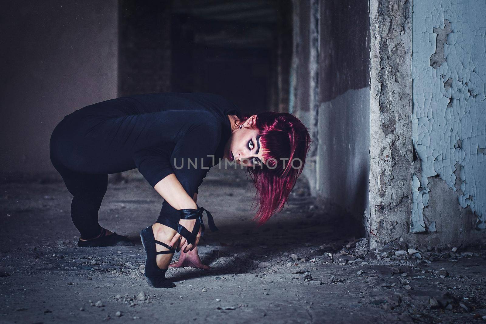 girl model in black with pink hair in an abandoned building