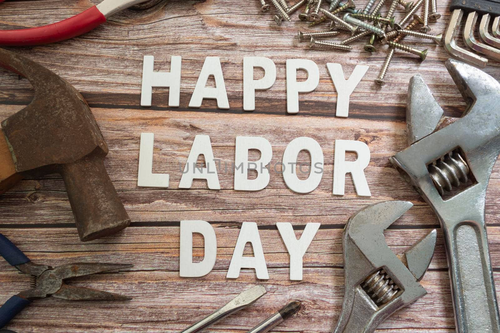 Happy labor day text with repair equipment and many handy tools on wooden background