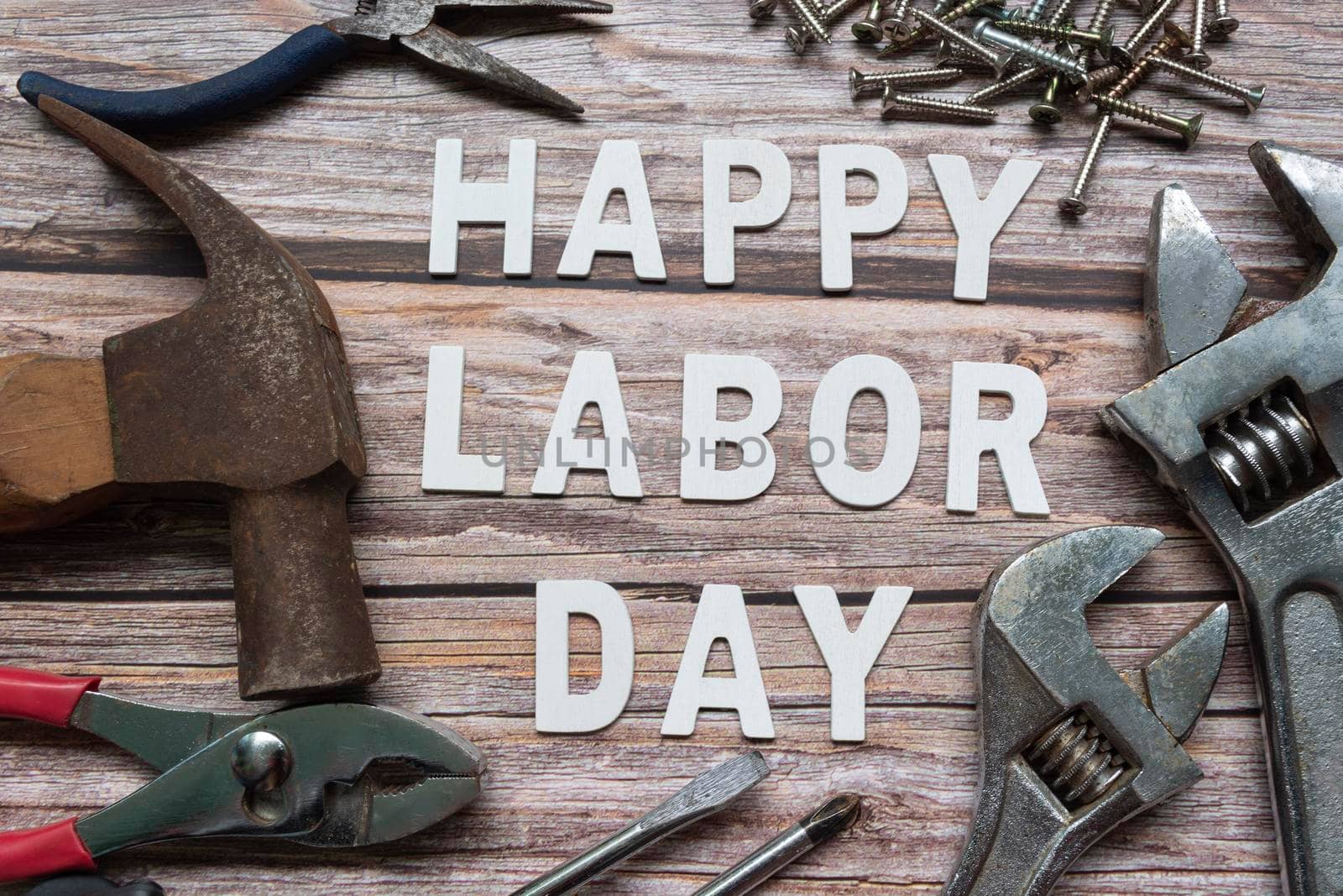 Happy labor day text with repair equipment and many handy tools on wooden background