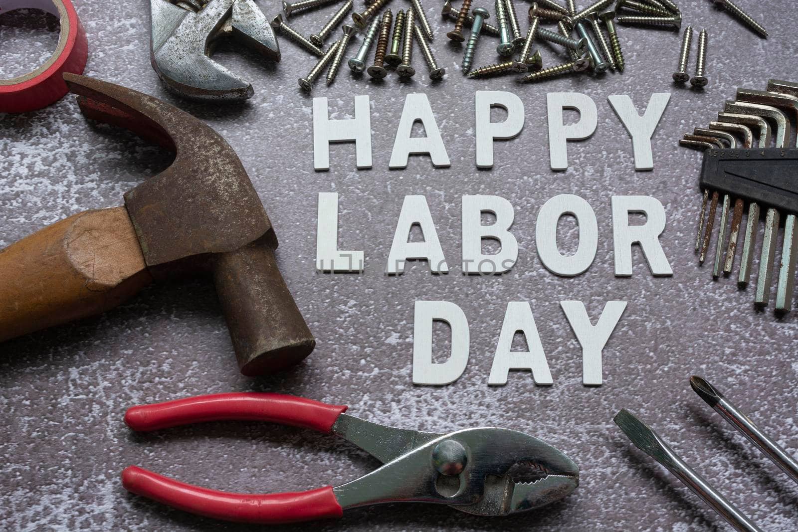 Happy labor day text with repair equipment and many handy tools on grunge grey concrete background