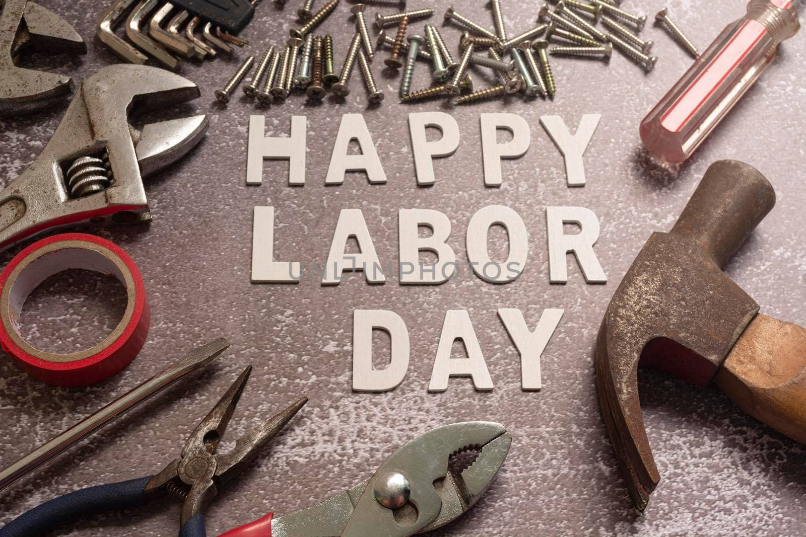 Happy labor day text with repair equipment and many handy tools on grunge grey concrete background