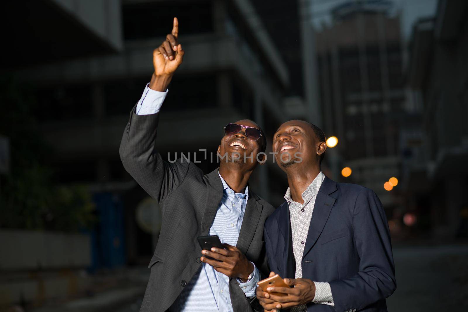 Meeting of businessmen standing outdoors in the evening after work and looking over them