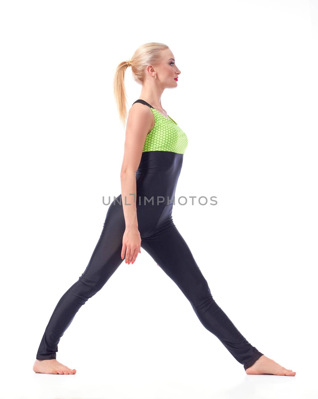 Focused on fitness. Full length studio shot of a female gymnast preparing to do splits posing isolated on white sports gymnastics fitness concept