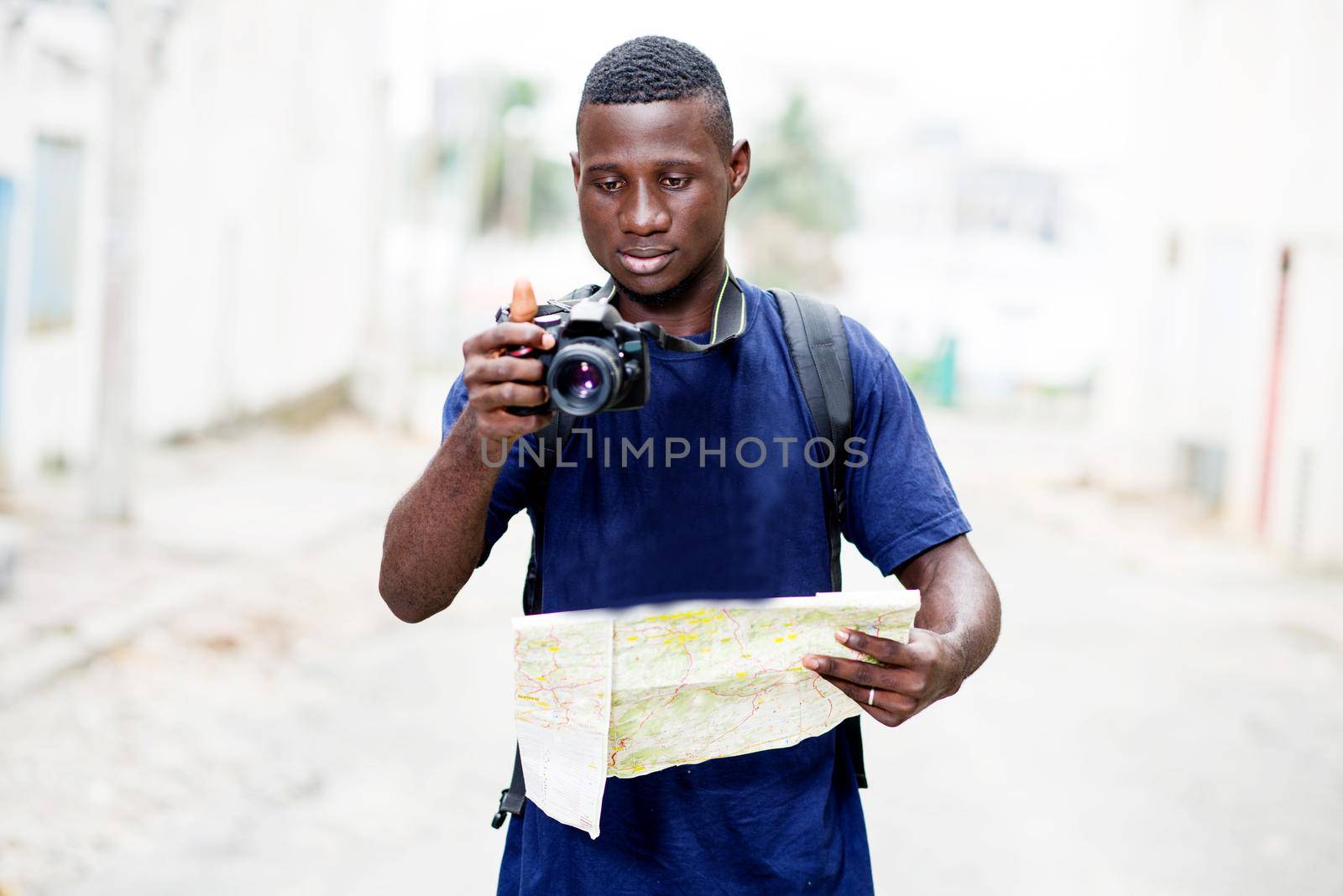 Portrait of a young tourist man looking at a map. Outdoor tourism concept