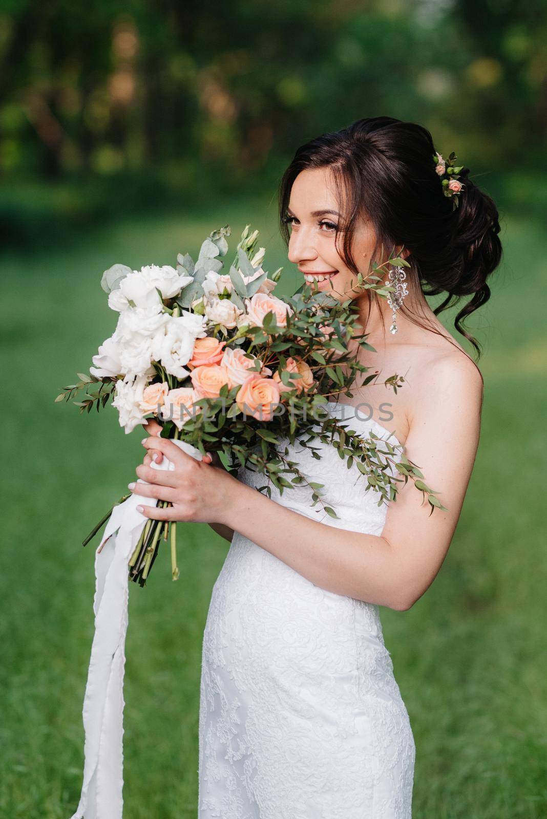 bride in a white dress with a large spring bouquet by Andreua