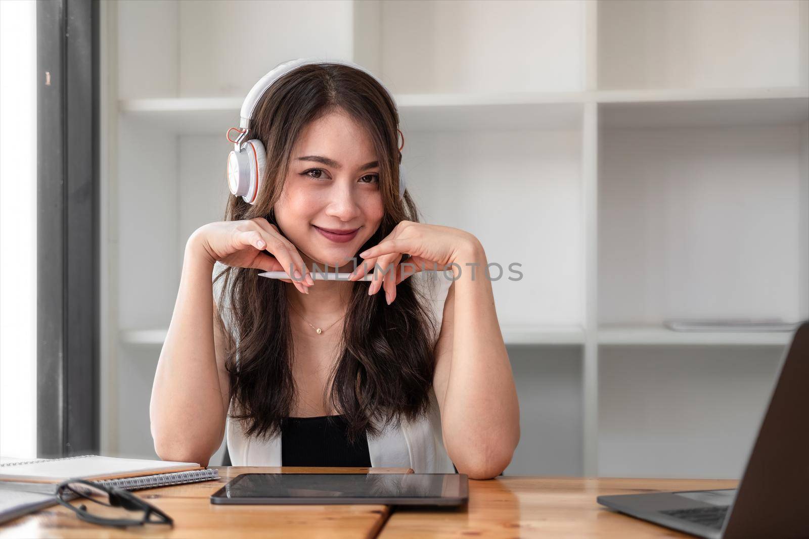 Portrait attraction asian Woman wear headset laugh using digital teblet for video stream conference call teach online.