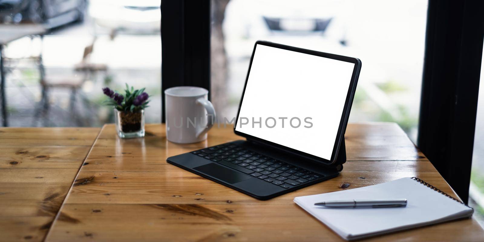 Mockup image of a black tablet with white blank screen on wooden desk. by itchaznong