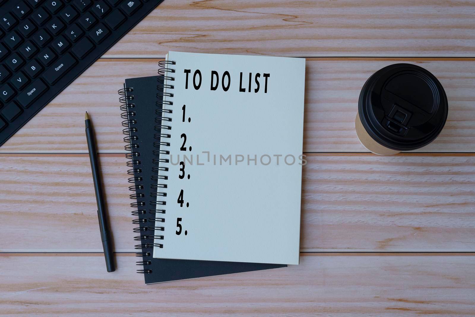 Text on notepad with pen, note book, keyboard and coffee on wooden desk - To do list