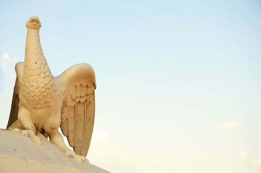 Statue fragment on an entrance in the Odessa opera theater - a bird the Phoenix, against the blue sky.