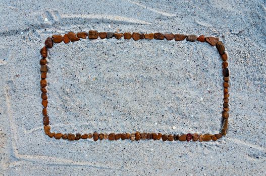 Abstract beach background - stone frame on the sand.